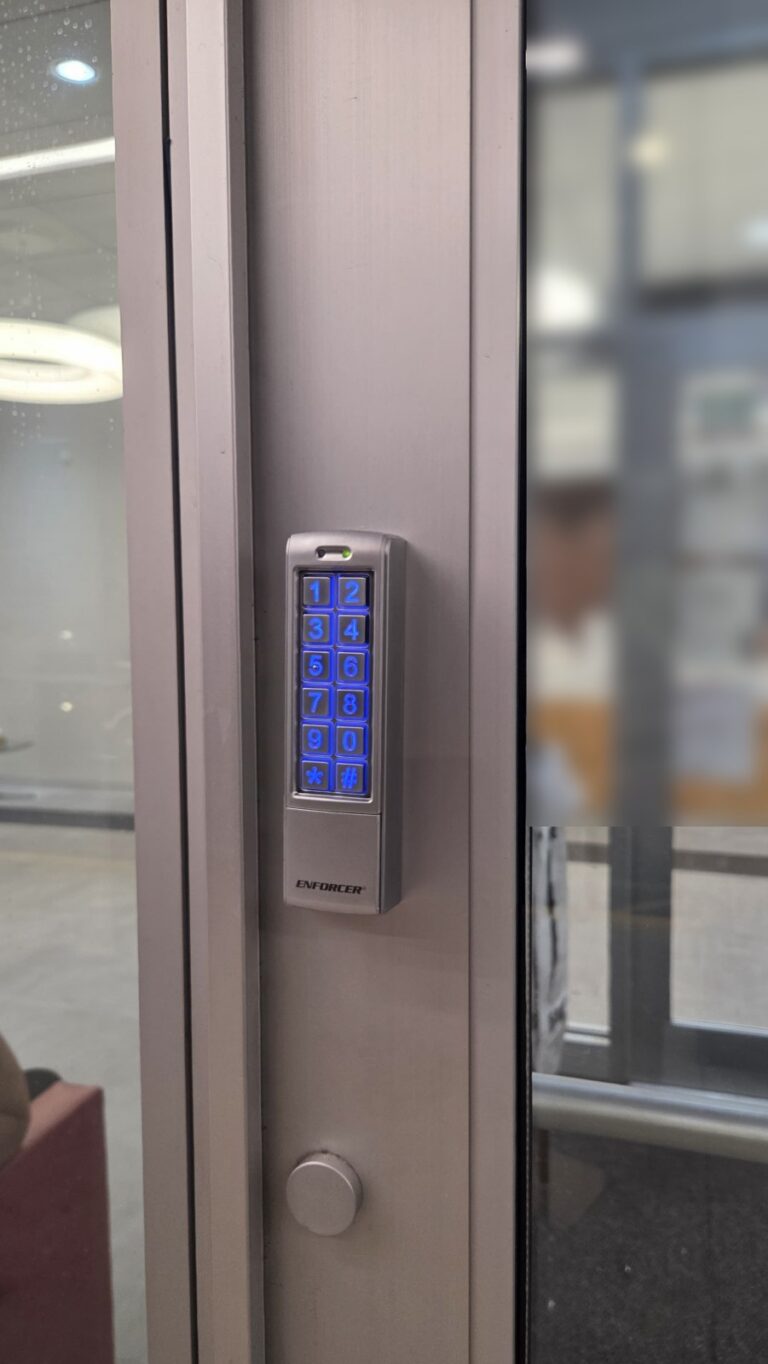 Backlit keypad on an aluminum storefront door frame for code entry, installed by Metro Local Locksmith in the Bronx, NYC