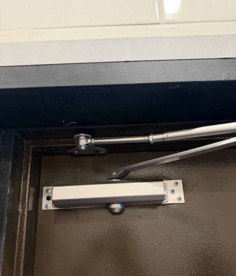 Commercial door closer with a mounting plate, installed by Metro Local Locksmith on the Upper East Side, Manhattan