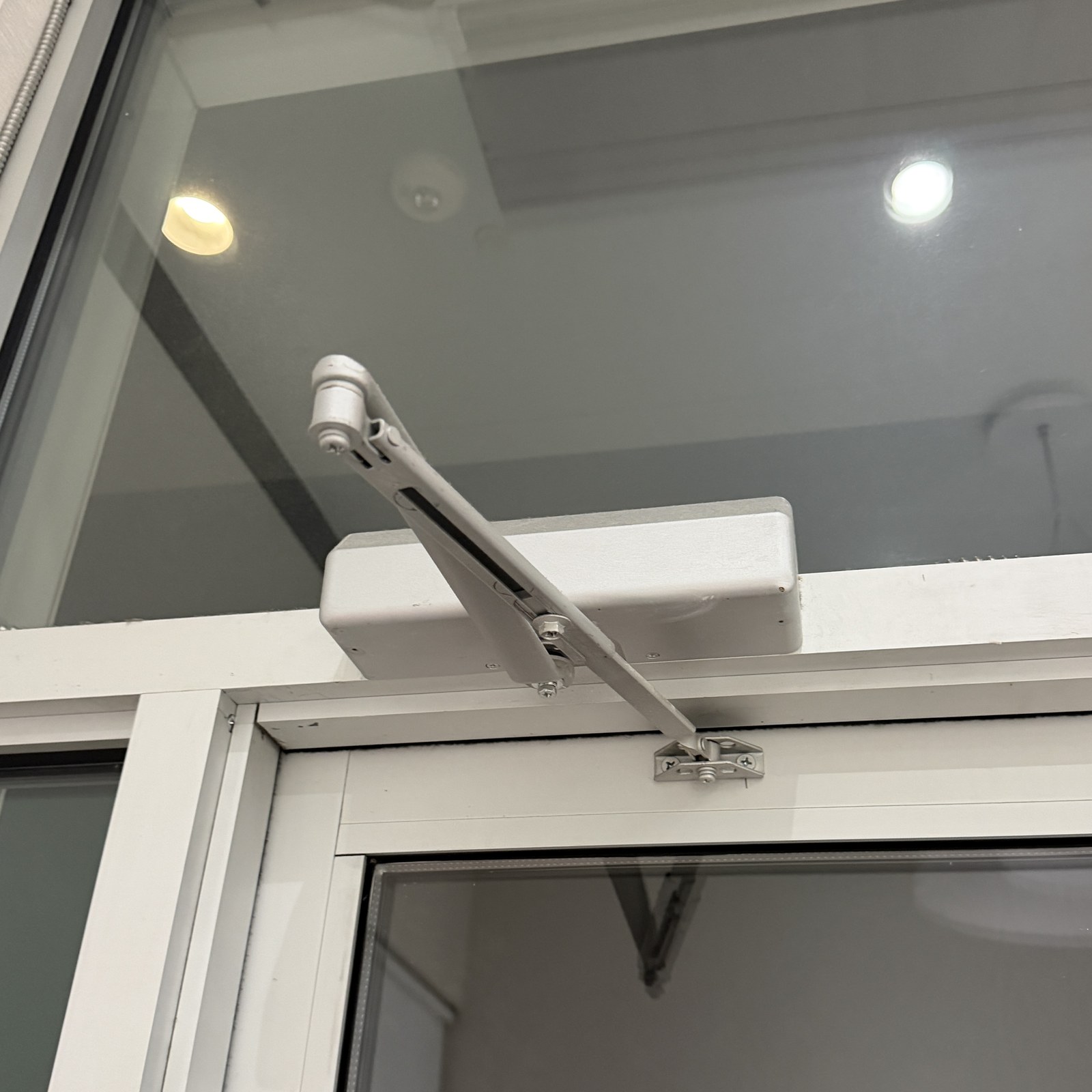 Commercial door closer on storefront door - Metro Local Locksmith Heavy-duty commercial door closer installed on an aluminum storefront door by Metro Local Locksmith, Upper East Side, Manhattan