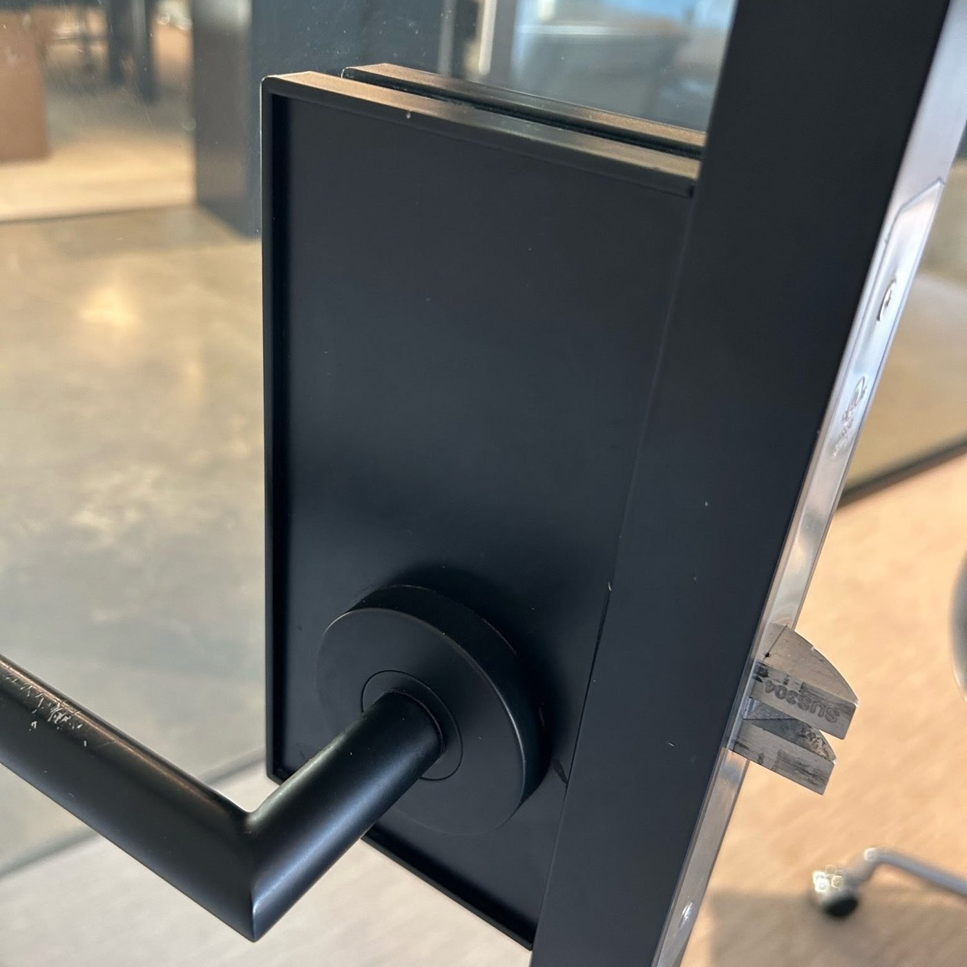 Black lever lock on a black-framed commercial glass door, Metro Local Locksmith