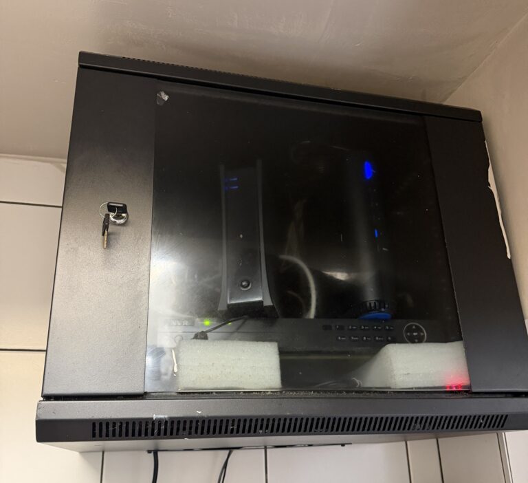 Locked wall-mounted enclosed equipment rack with a glass door and a DVR inside, installed by Metro Local Locksmith on the Upper East Side, Manhattan