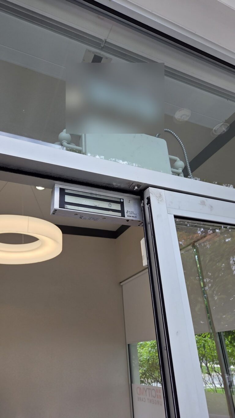 Hard-wired maglock on the header of a commercial glass entrance, rewired by Metro Local Locksmith in Hartsdale, Westchester