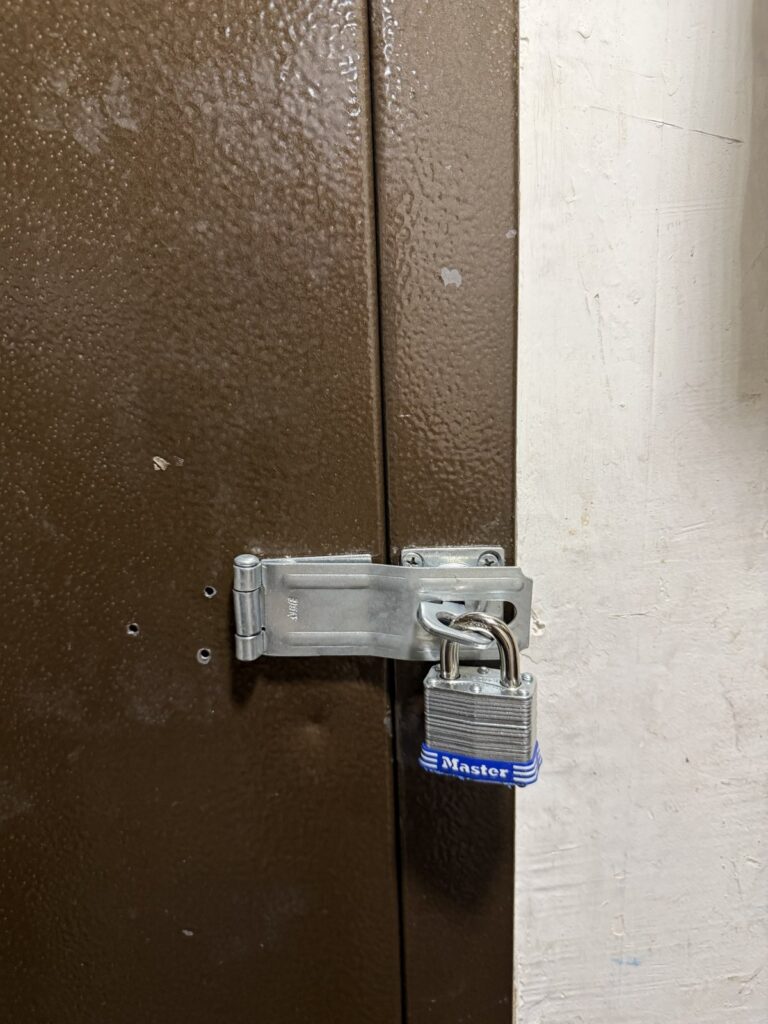 Close-up of a heavy-duty hasp with a laminated padlock, installed by Metro Local Locksmith on the Upper East Side, Manhattan