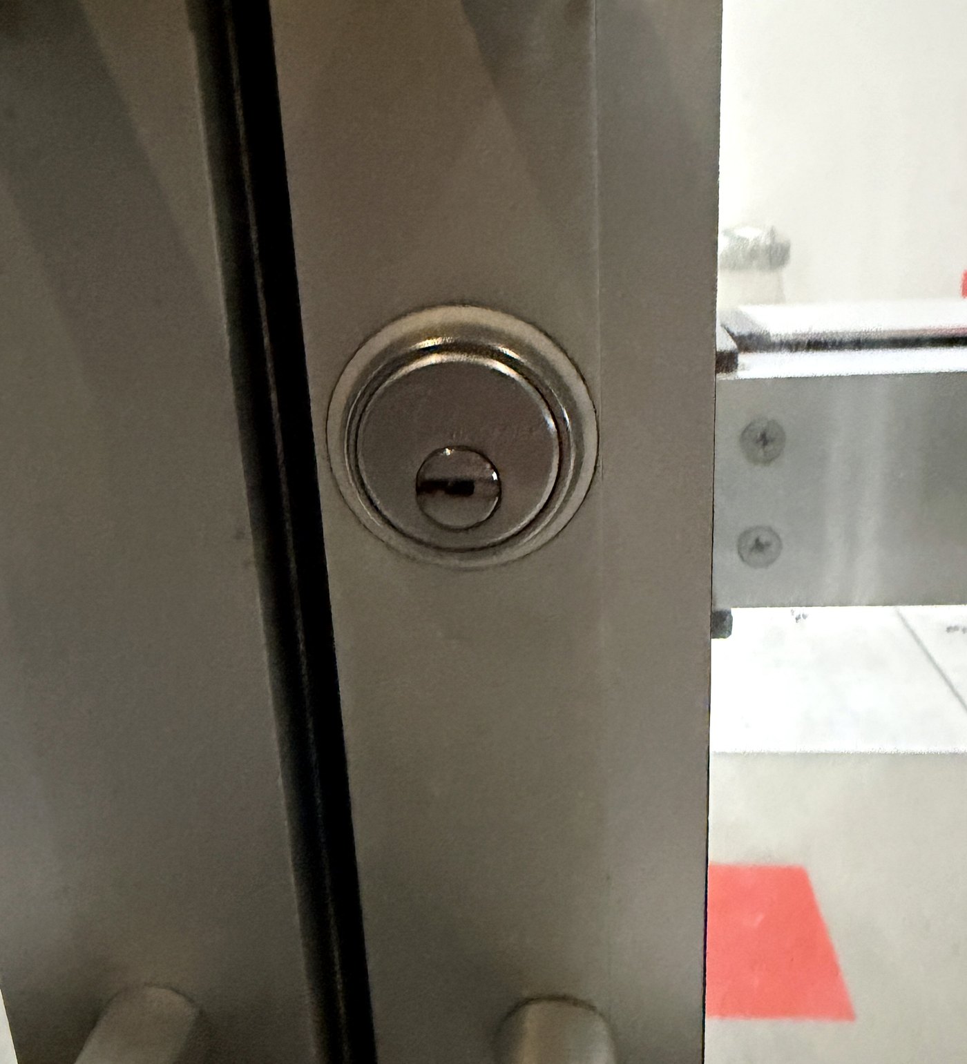 High-security cylinder on storefront door - Metro Local Locksmith High-security cylinder with a restricted keyway on a commercial storefront door, installed by Metro Local Locksmith