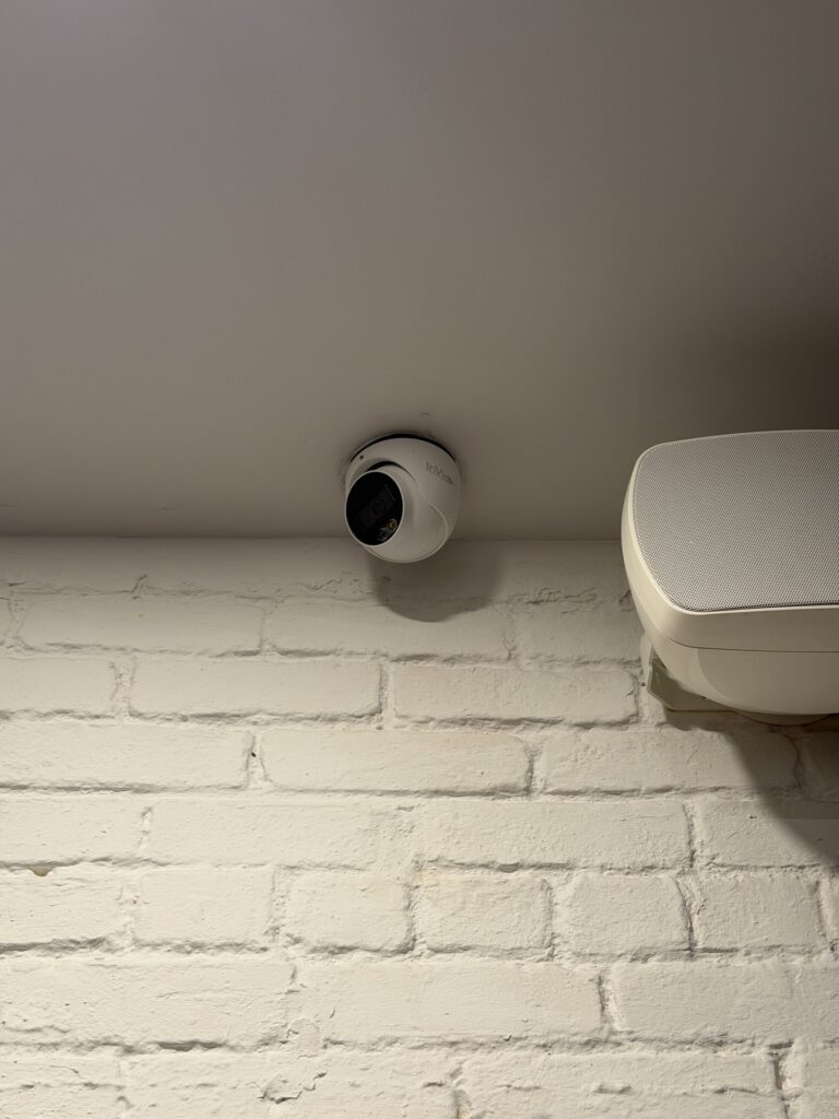 InVid dome security camera mounted above a white brick wall, installed by Metro Local Locksmith on the Upper East Side, Manhattan