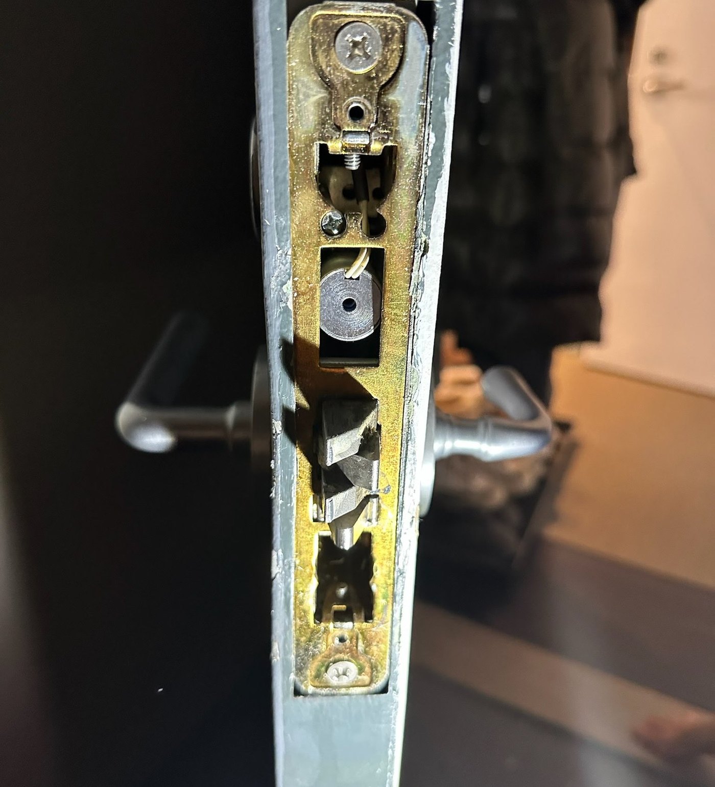 Mortise lock body exposed in the edge of an apartment door during a lock repair by Metro Local Locksmith, NYC
