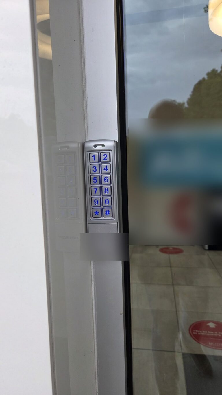 Old keypad on a commercial glass entrance before the upgrade by Metro Local Locksmith in Hartsdale, Westchester
