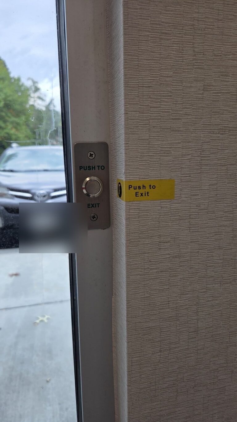 Push-to-exit button inside a commercial glass entrance, installed by Metro Local Locksmith in Hartsdale, Westchester