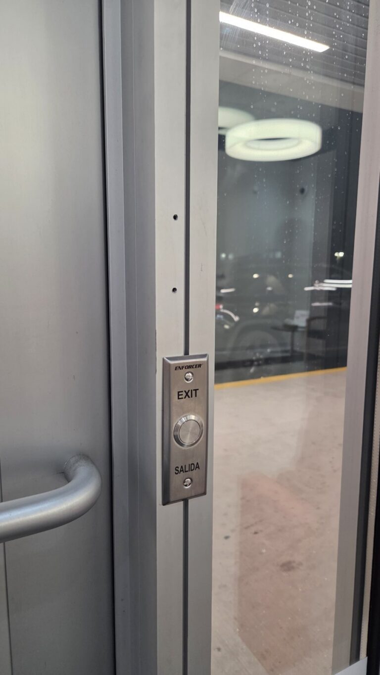 Push-to-exit button beside a storefront entry door, installed by Metro Local Locksmith in the Bronx, NYC