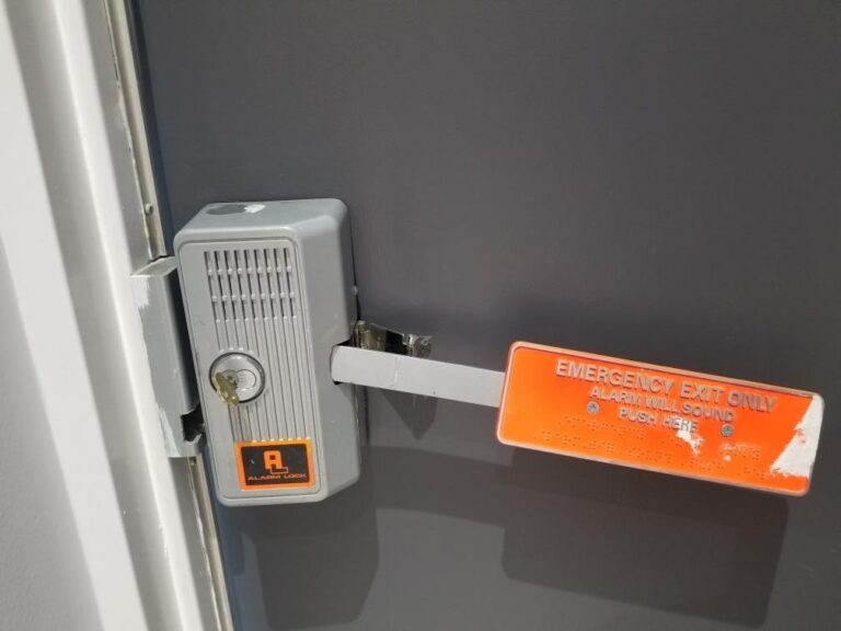 Keyed exit alarm with a push paddle on a rooftop access door, installed by Metro Local Locksmith on the Upper East Side, Manhattan