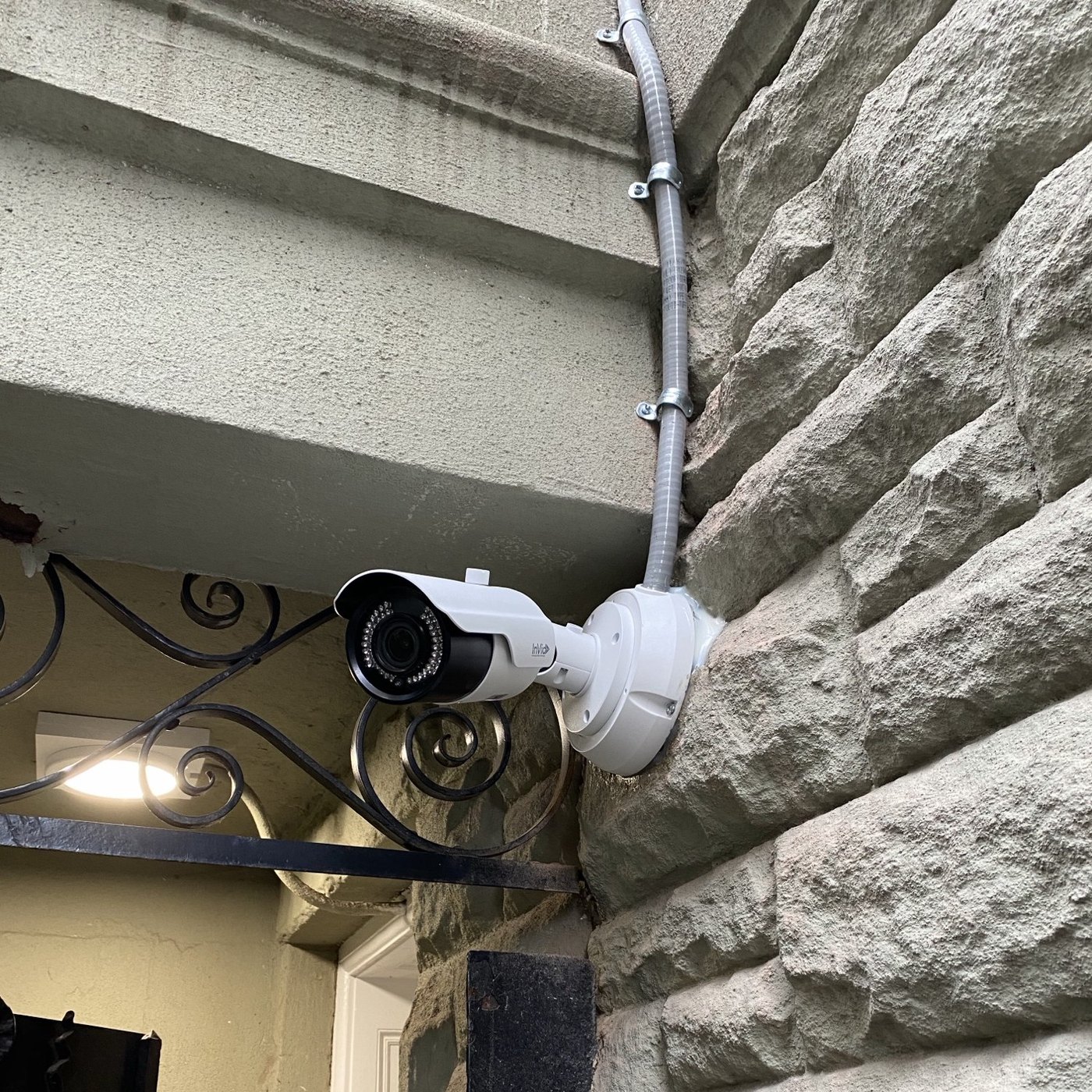 Security camera on stone building entrance - Metro Local Locksmith Security camera mounted on the stone facade of an NYC building entrance, Metro Local Locksmith