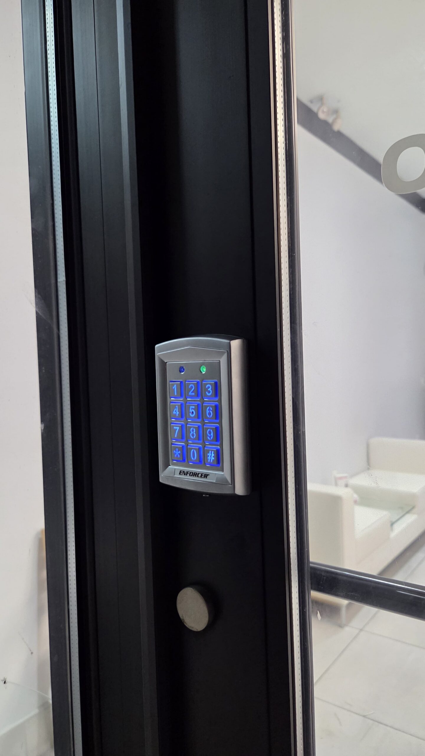 Backlit Enforcer keypad for keyless entry installed on an aluminum storefront door frame, Bronx, NYC