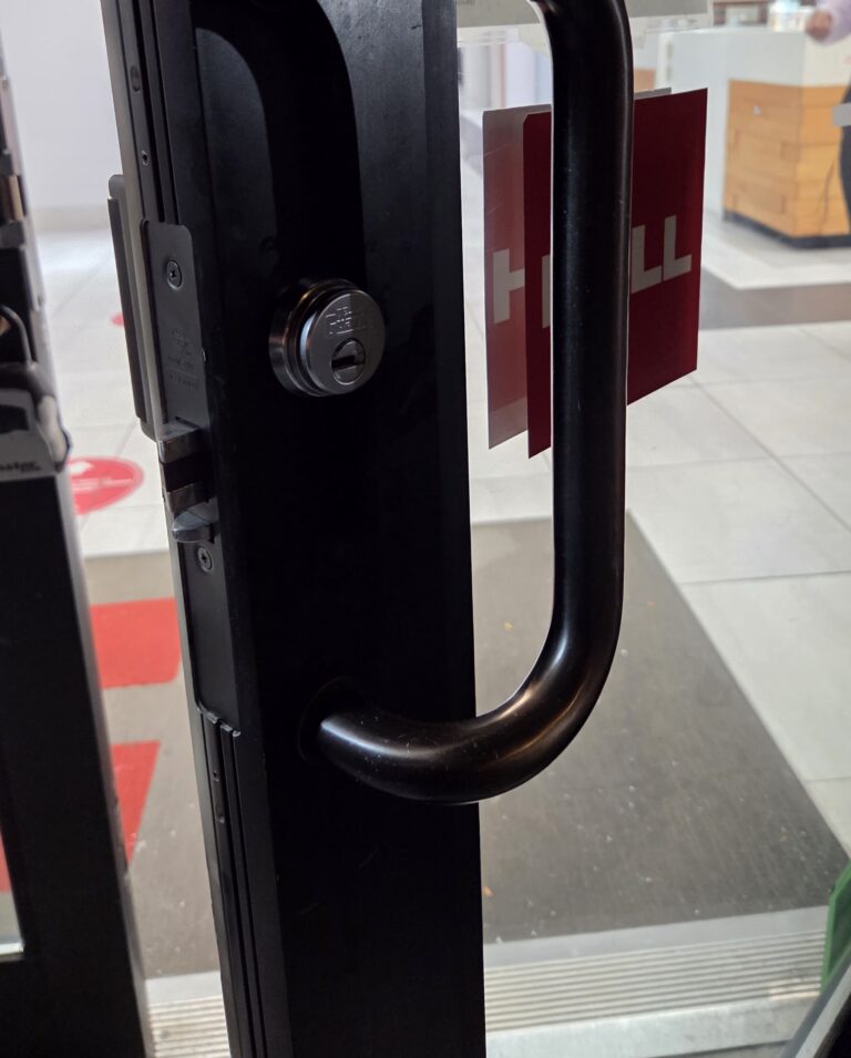 Offset pull handle with keyed cylinder on a commercial aluminum glass door, Bronx, NYC